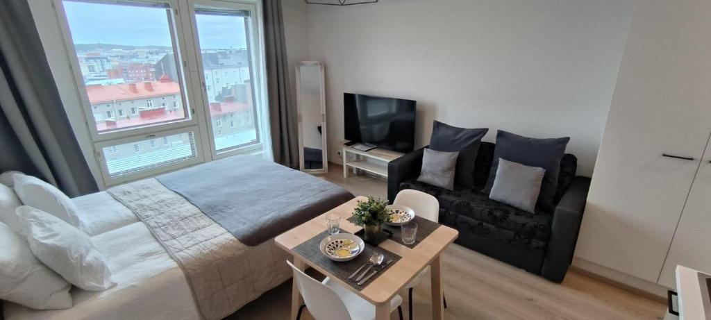 a bedroom with a bed and a couch and a table at StyleStudio Areena1 in Tampere