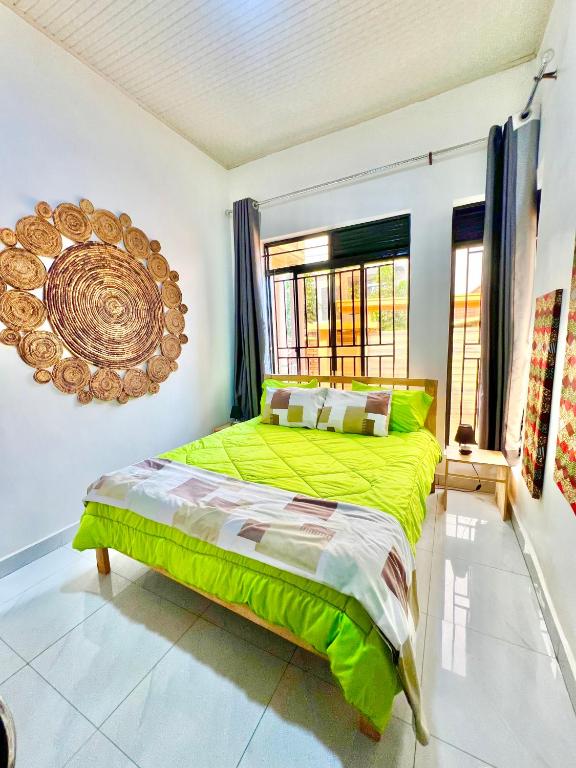 - une chambre avec un lit vert et une fenêtre dans l'établissement Rwanda Guest House Kanombe, Kigali, à Kigali