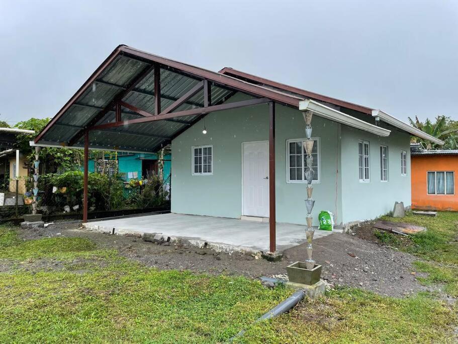 una piccola casa verde con un grande garage di Casa Colibrí, entera, Volcán a Volcán