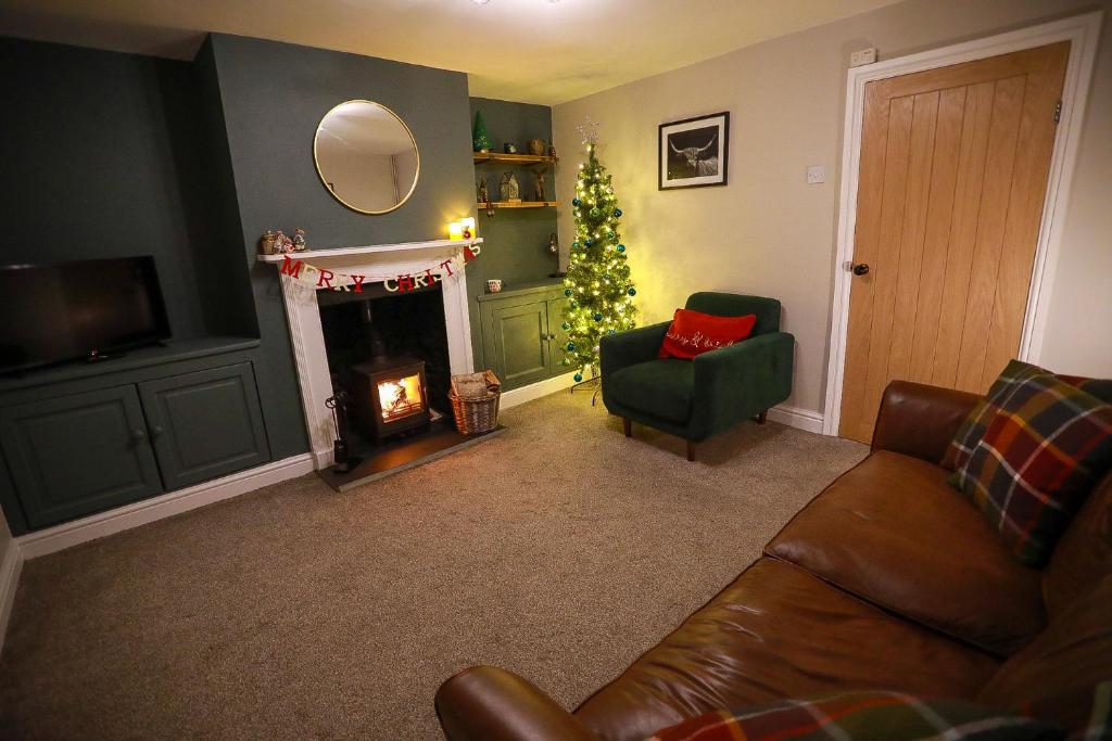 a living room with a christmas tree and a couch at Auctioneers Cottage in Louth