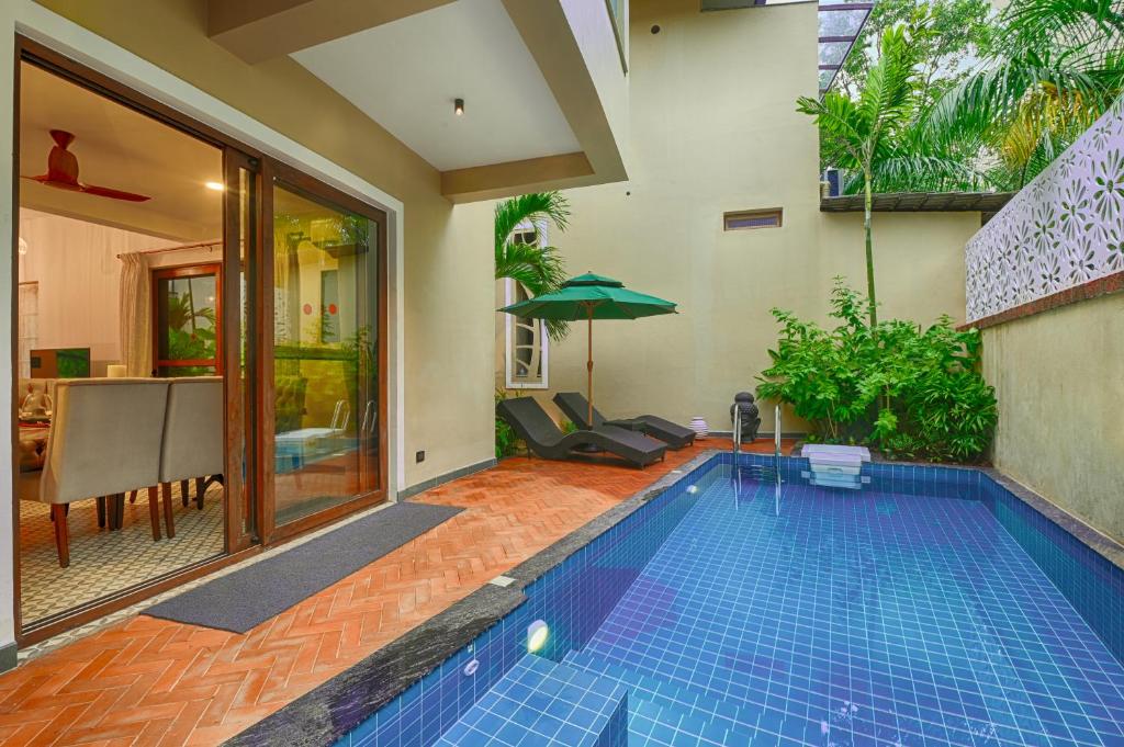 a swimming pool in the middle of a house at Melhor Stays Villa - L-A3 Luxurious 3BHK villa with private pool, Assagao in Vagator
