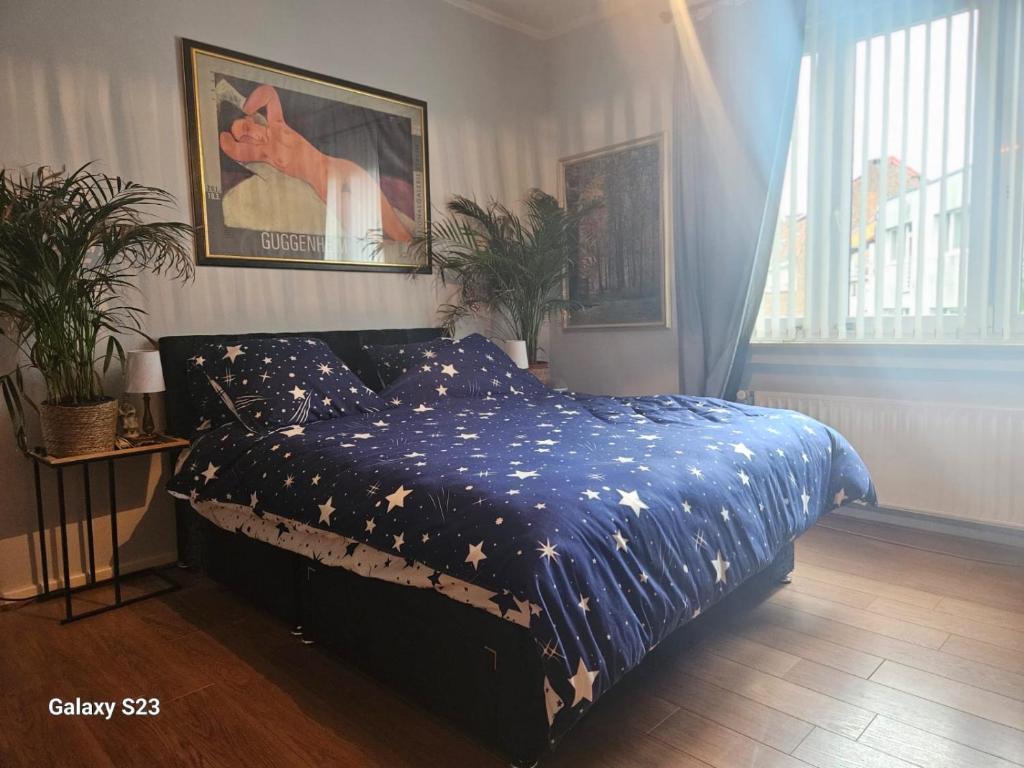 a bedroom with a bed with a blue comforter with stars at Serenity Big Room in Brussels