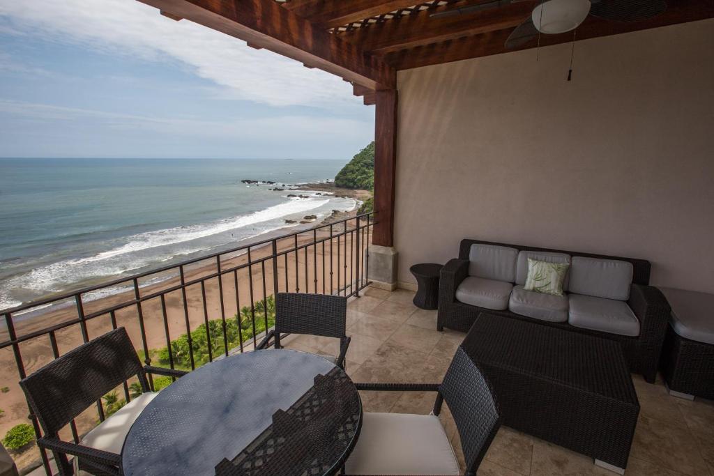 ein Balkon mit Tisch und Stühlen und dem Meer in der Unterkunft Spectacular 3 bedroom Penthouse at Crocs Resort Casino in Jacó