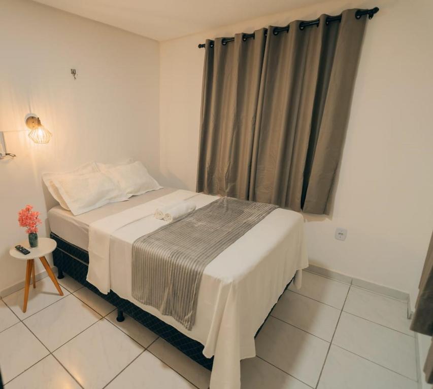 ein kleines Schlafzimmer mit einem Bett und einem Fenster in der Unterkunft Grande Apartamento Com 3 Quartos e Uma Localização Privilegiada in Campina Grande