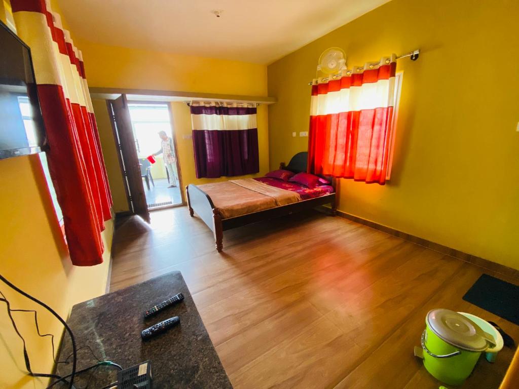 a small room with a bed and red curtains at Vibe n rejoice in Ooty