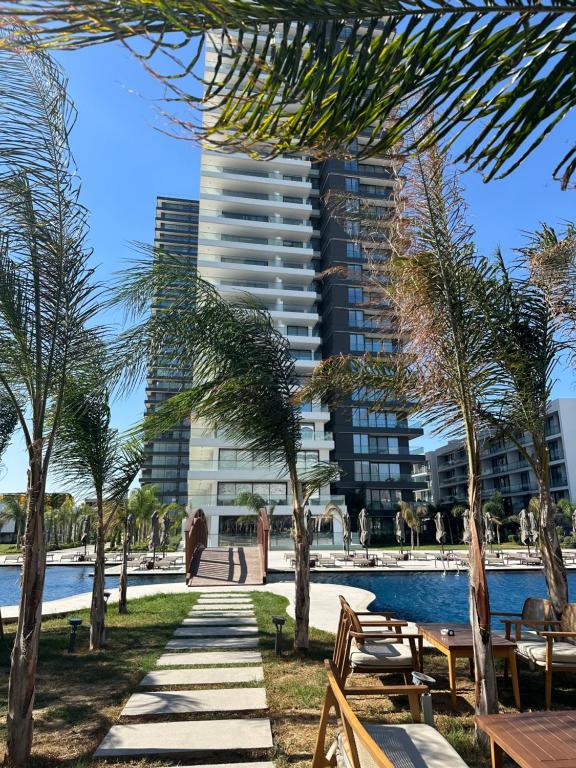 a pool with palm trees and a tall building at Grand Sapphire Casino studio 20 in Iskele