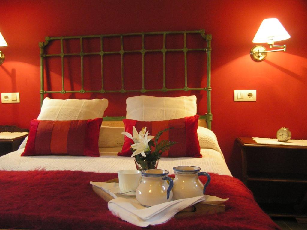 una camera d'albergo con un letto con pareti rosse di Casa Rural Don Romualdo a Casar de Palomero