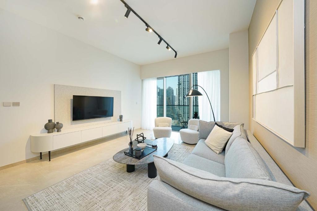 a living room with a couch and a tv at Holiday Retreat at touching distance to Burj Khalifa, downtown Dubai in Dubai