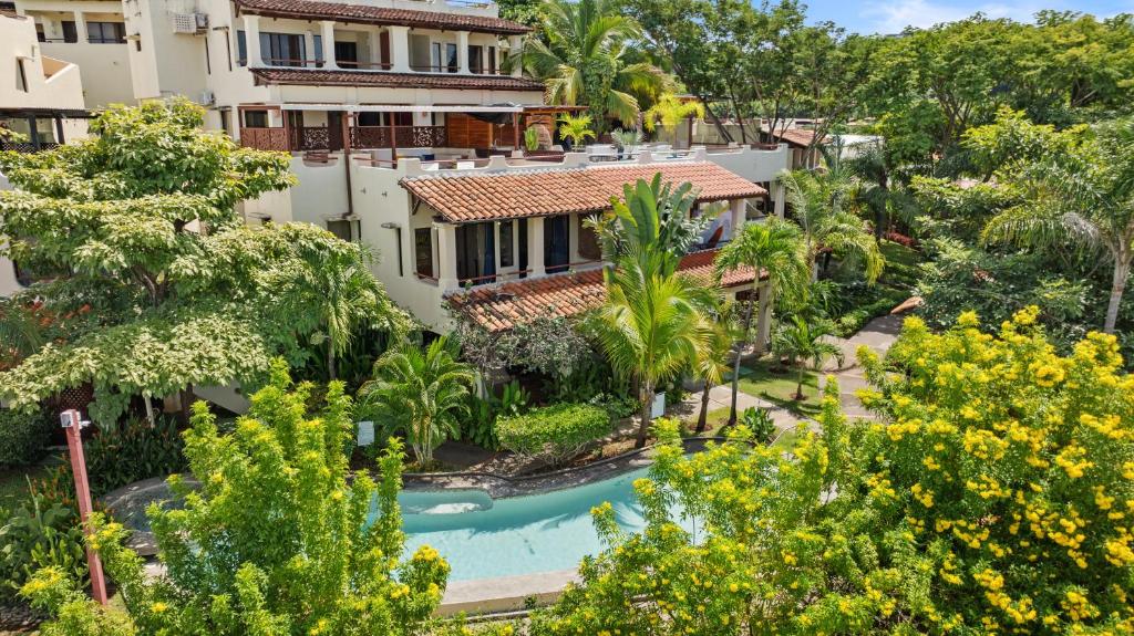 an aerial view of a resort with a pool and trees at Sunshine Escape with a Rooftop Patio in Coco