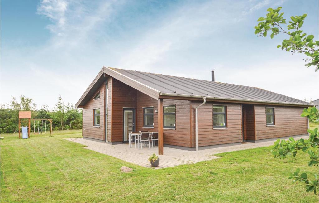 a small wooden house with a grass yard at Holiday Home Bronzehøjen Højslev in Bøstrup