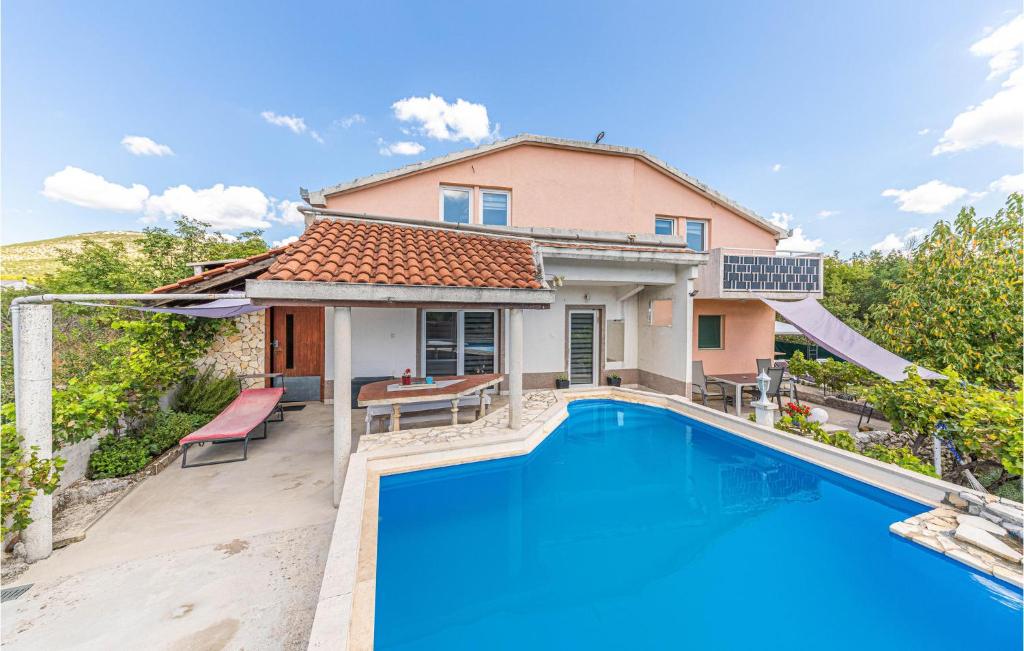 a villa with a swimming pool in front of a house at Cozy Apartment In Labin With Wifi in Labin