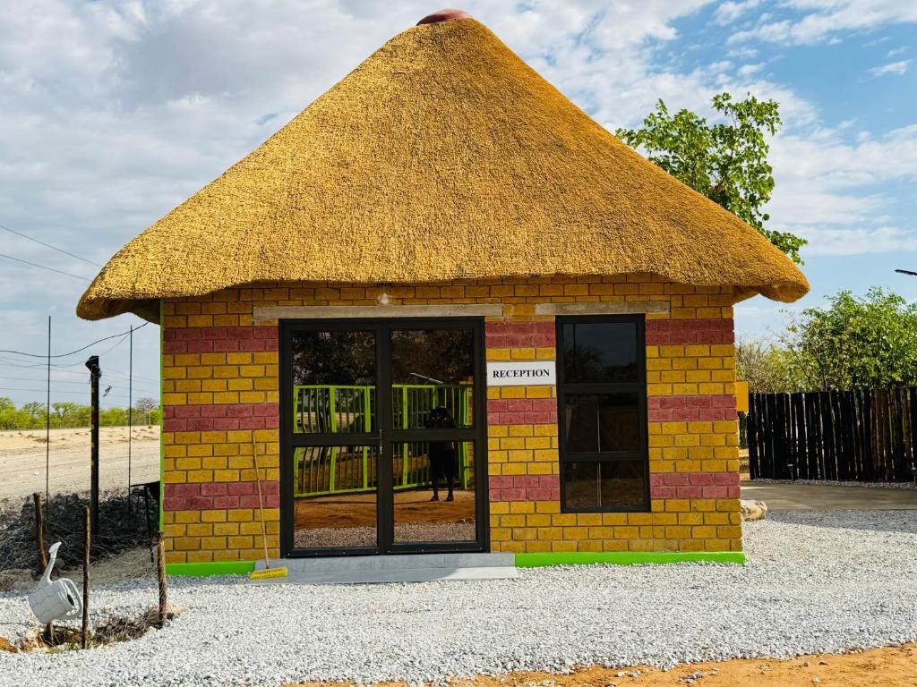 a small brick building with a thatch roof at Endambo Hides Lodge in Amakange