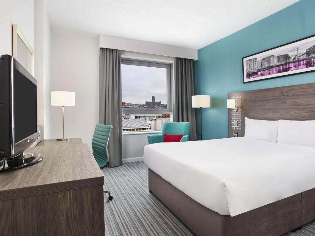 a hotel room with two beds and a television at Jurys Inn Liverpool in Liverpool