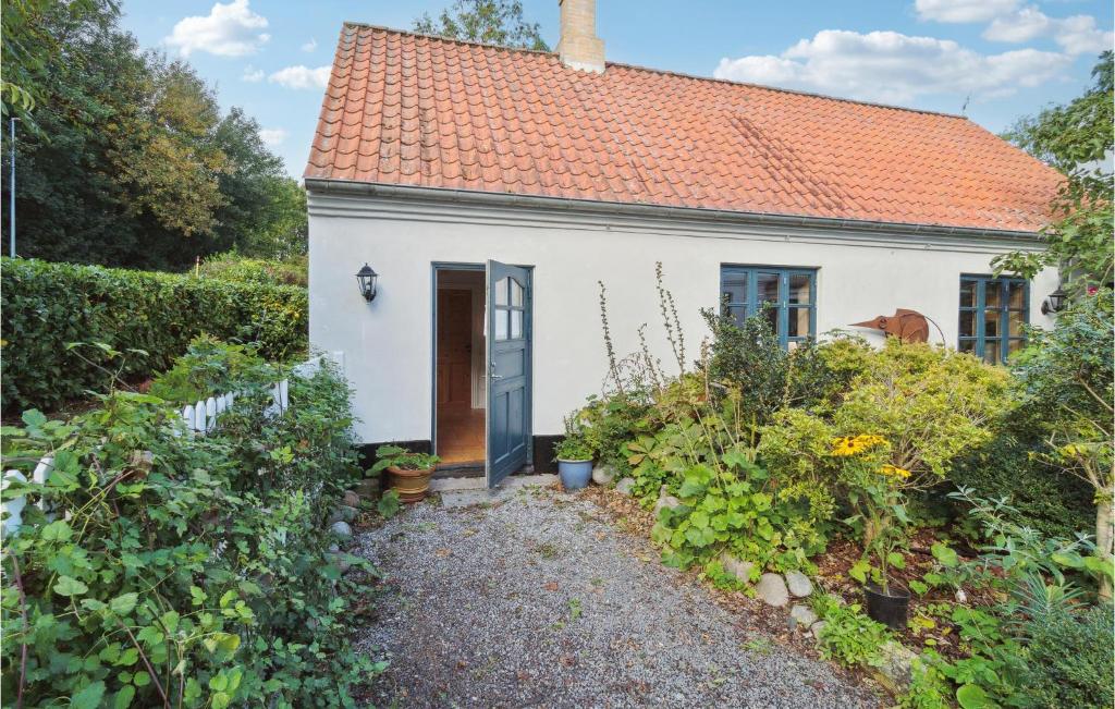 a small white house with an orange roof at Stunning Apartment In Svaneke in Svaneke