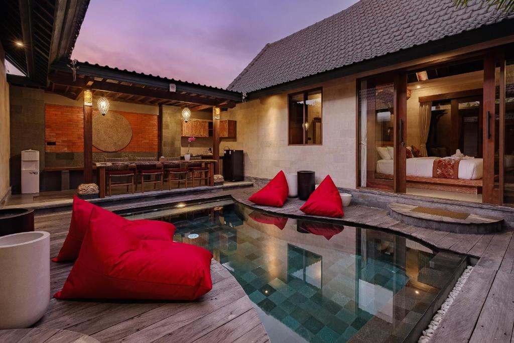 a room with a pool with red pillows and a bedroom at Monique Ubud Villa in Ubud