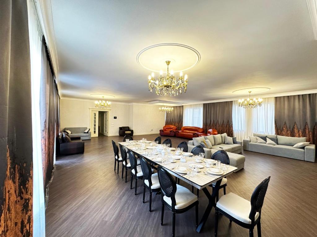 a dining room with a long table and a living room at Nizami Luxury Apart in Baku