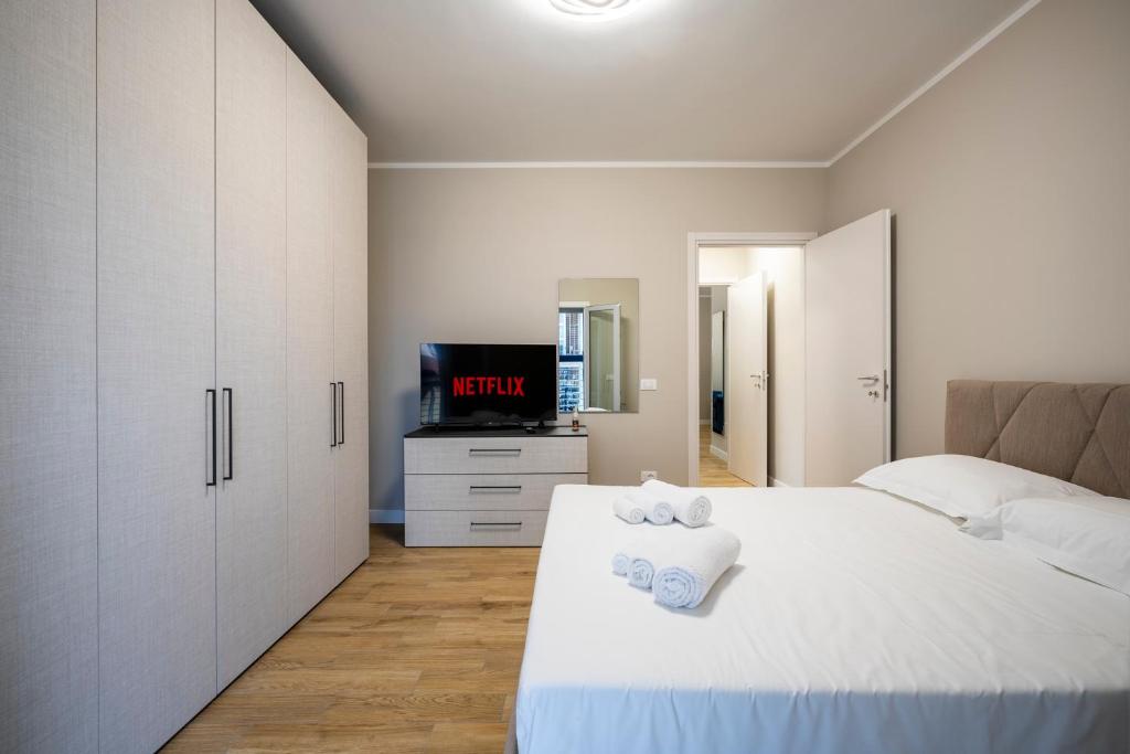ein weißes Schlafzimmer mit einem Bett und einem Fernseher in der Unterkunft Venovela Luxury Retreat - Private Free Parking in Florenz