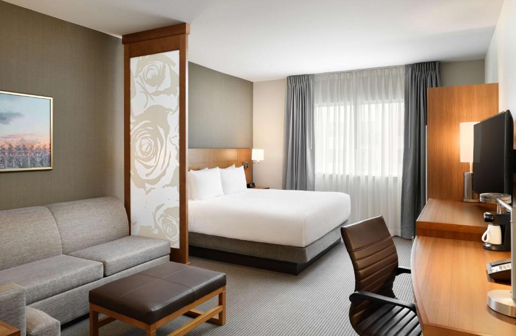 a hotel room with a bed and a couch at Hyatt Place Pasadena in Pasadena