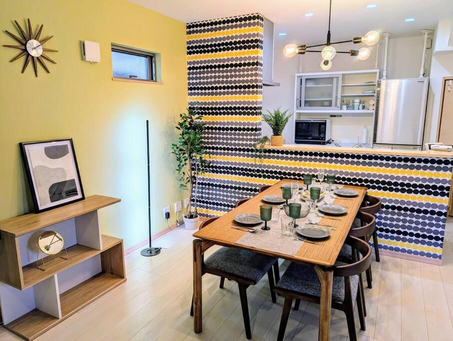 een eetkamer met een tafel en een keuken bij メイプルヒルイン府中多磨 in Fuchu