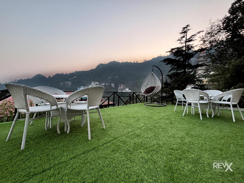 un gruppo di sedie e un tavolo sull'erba di Hotel Wraveler Inn Mussoorie a Mussoorie