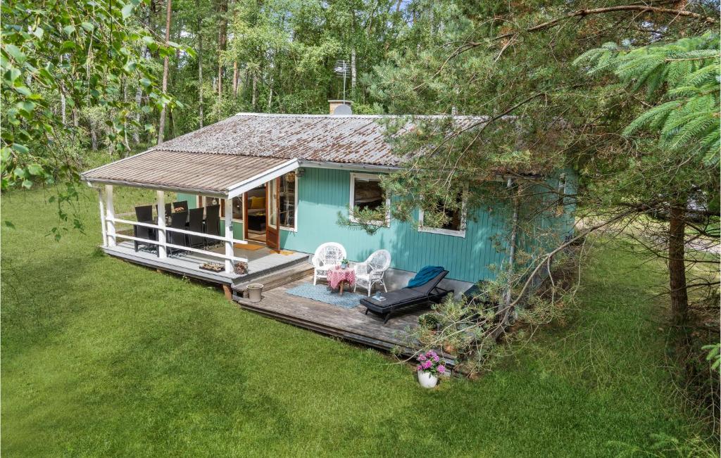 ein blaues Häuschen mit einer Terrasse im Gras in der Unterkunft 3 Bedroom Beautiful Home In Nexø in Neksø
