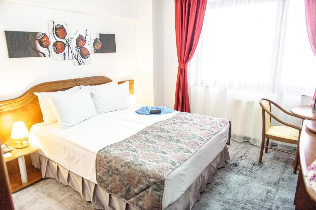 a hotel room with a bed and a window at Hotel Parc Sibiu in Sibiu