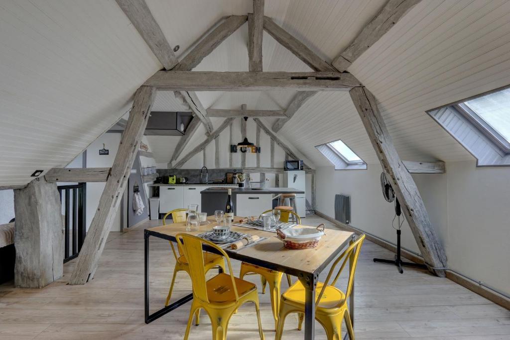 une salle à manger avec une table et des chaises jaunes dans l'établissement Le Rabelais - Appt à 5min du château dAmboise, à Amboise