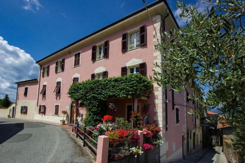 un edificio rosa con flores delante en La Casa del Dottore, en Tendola