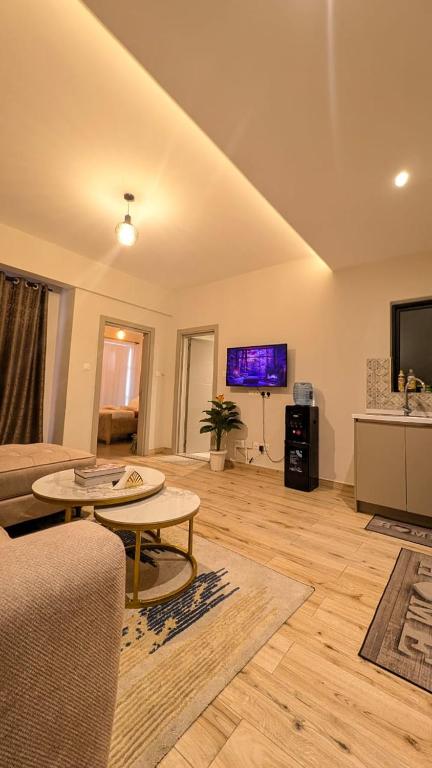 a living room with a couch and a table and a tv at City Pen - By Tito Homes in Nairobi