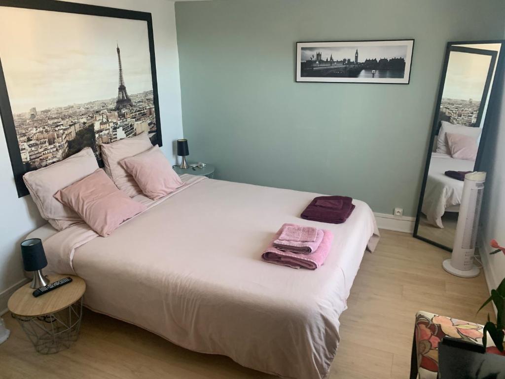 une chambre avec un grand lit blanc avec des oreillers roses dans l'établissement Maison de centre-ville, à Cognac