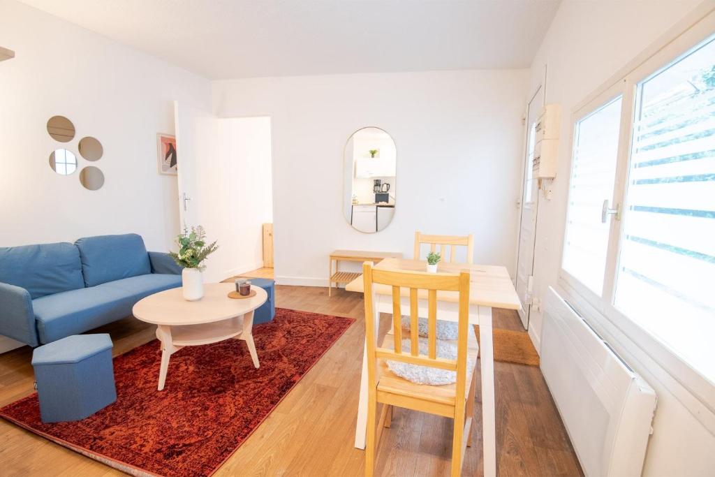 un salon avec un canapé bleu et une table dans l'établissement L Ecrin Amboisien, à Amboise