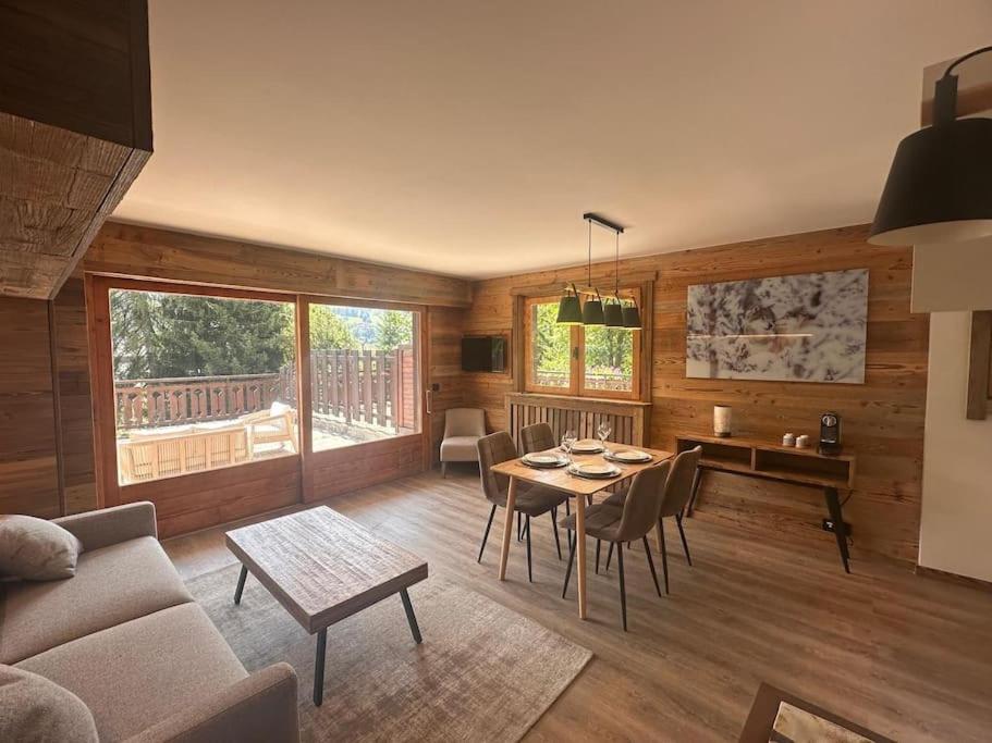 a living room with a table and a dining room at Studio Cosy cœur de Megève Le Soleil Levant in Megève