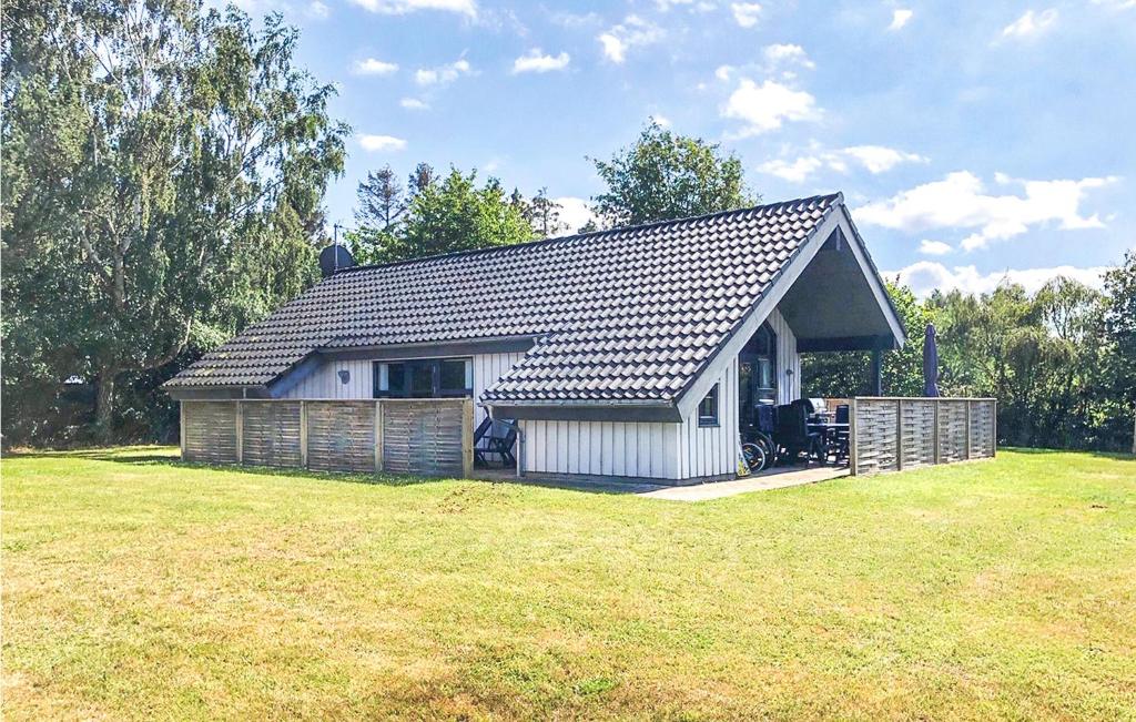 una pequeña casa blanca con un gran patio en Holiday Home Morsøvej Glesborg Denm, en Bønnerup