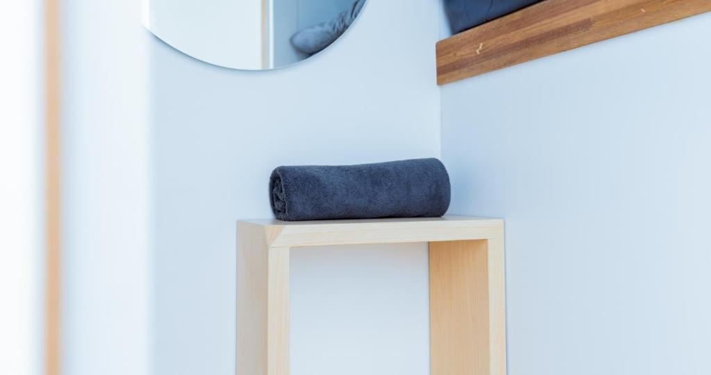 a blue wallet sitting on a stool in front of a mirror at Bobopod Kota Tua, Jakarta in Jakarta