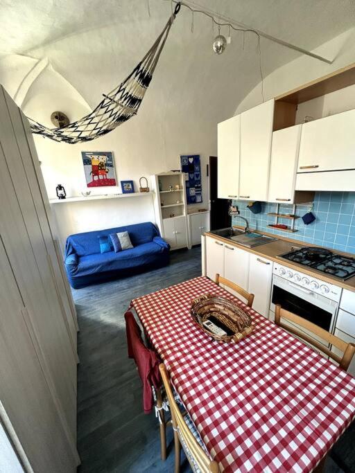 a kitchen with a table with a red and white checkered table cloth at Suite Palazzo - Sanremo in Sanremo