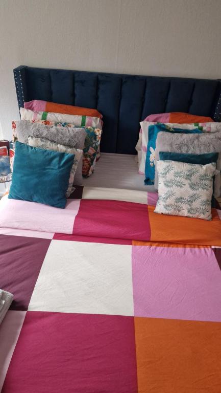 - un lit avec une couverture et des oreillers colorés dans l'établissement Place Joice, à Nantes