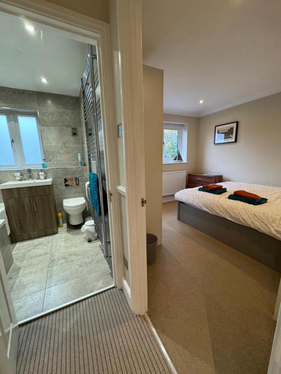 ein Schlafzimmer mit einem Bett und ein Badezimmer mit Dusche in der Unterkunft Tranquil Barnet in Barnet