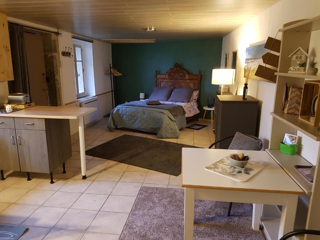 a bedroom with a bed and a table in a room at La Petite Maison du Gardien in Sainte-Agnès