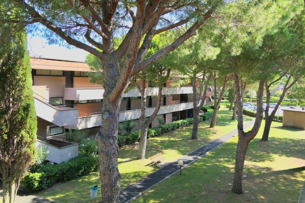 an apartment building with trees in front of it at IssTravel, Holiday Homes with common swimming-pool in Marina di Bibbona from 400 to 900 meters from the sea in Marina di Bibbona