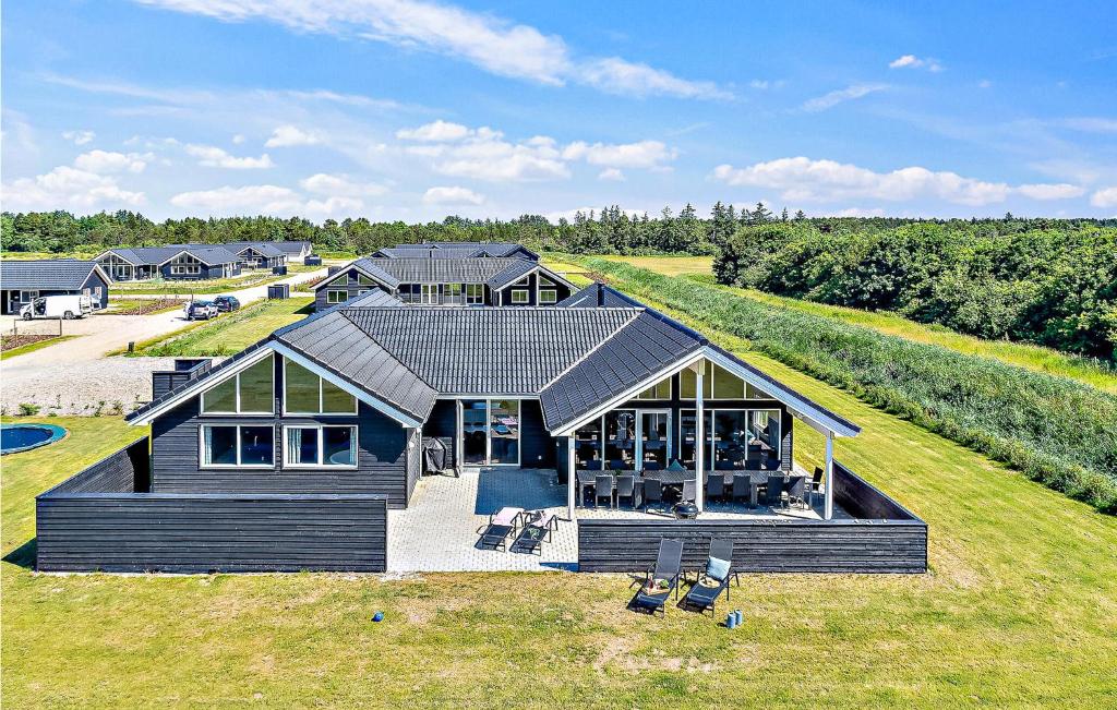 una grande casa con tetto su un prato di Cozy Home In Nørre Nebel With Sauna a Nørre Nebel