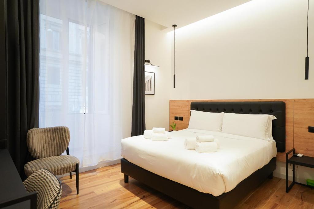 Hotel No Man's Land Guesthouse, a bedroom with a large bed and a chair at No Man's Land Guesthouse in Rome