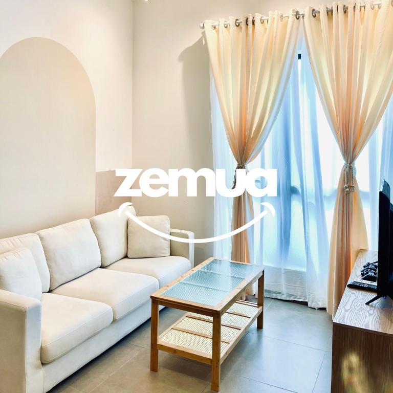un soggiorno con un divano bianco e un tavolo di MOSSAZ by ZEMUA Lv 26 Muji 2Rooms Near 1U IKEA a Petaling Jaya