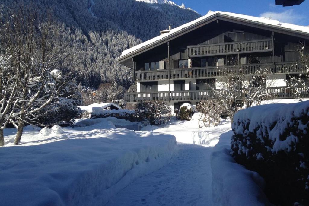 un lodge de ski avec une cour couverte de neige en face dans l'établissement Beautiful T2 with balcony near track, à Chamonix-Mont-Blanc