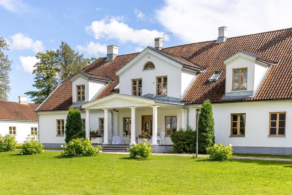 a white house with a red roof at Skangaļu muiža in Skangaļi