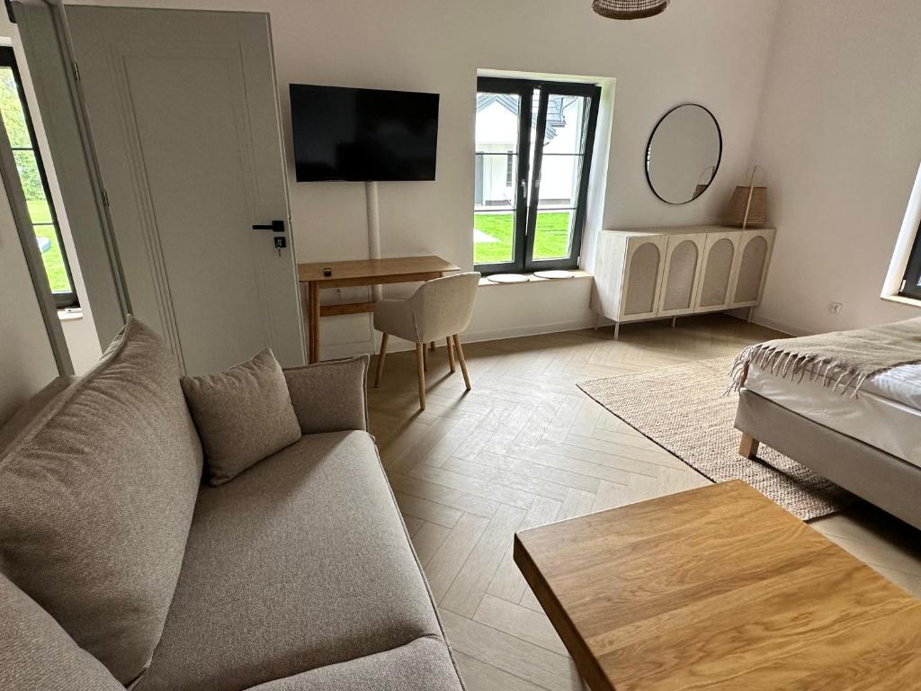 a living room with a couch and a table at Zakątek nad Wkrą in Goławice