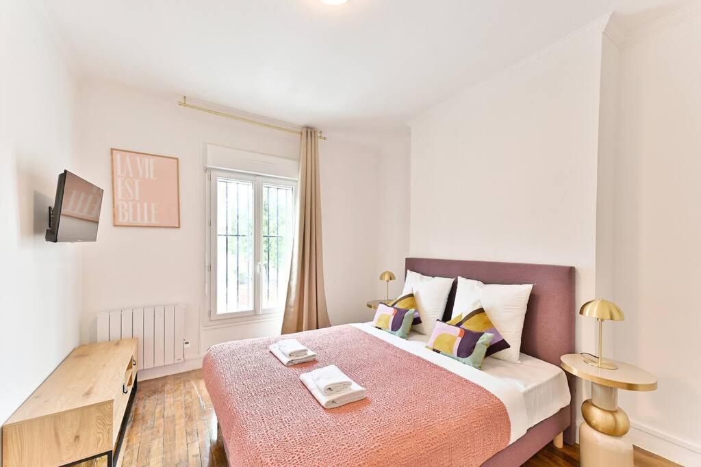 une chambre blanche avec un grand lit et une table dans l'établissement Studio cosy proche de la capitale - Montreuil - II, à Montreuil