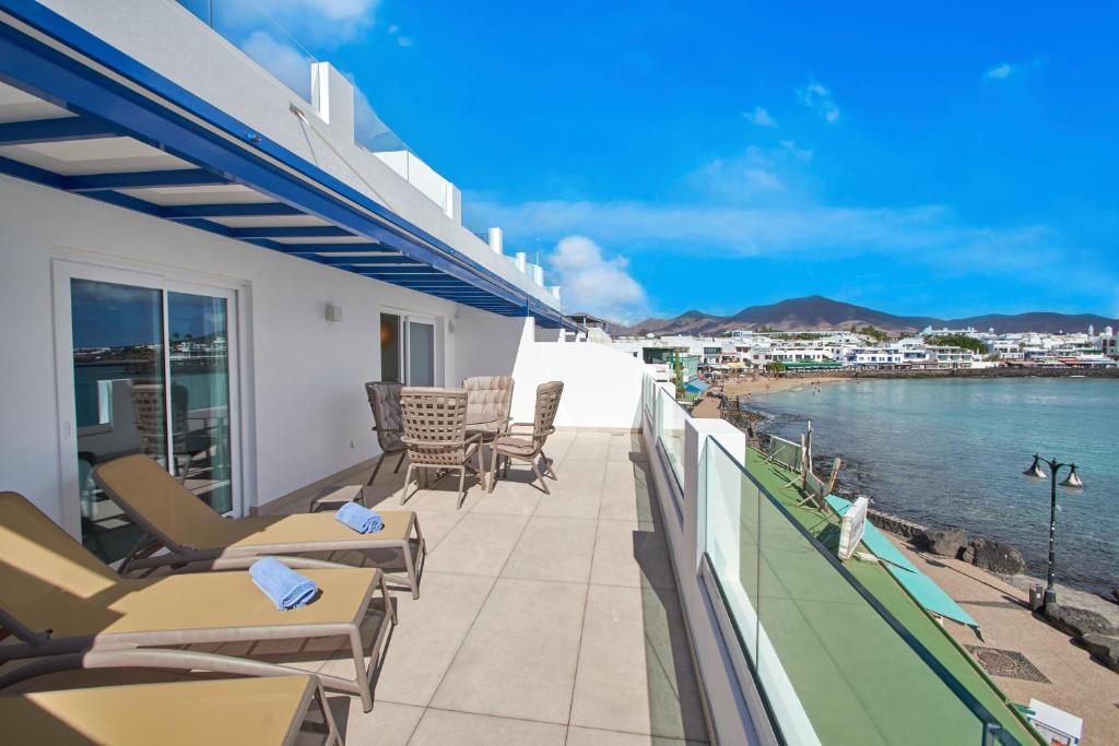 a balcony with chairs and a view of the ocean at Blancazul Deluxe Casa Domingo in Playa Blanca