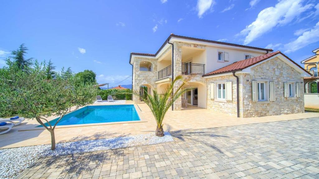 ein Haus mit einem Swimmingpool davor in der Unterkunft Luxury five stars villa with pool, near beach - by TRAVELER tourist agency Krk - ID 2140 in Pinezici