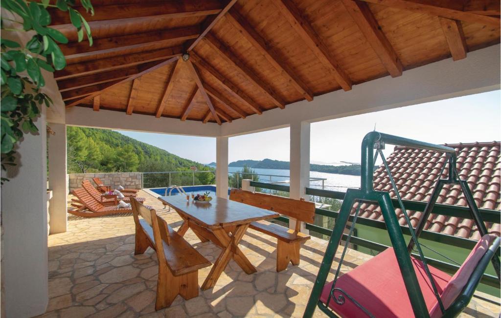 patio z drewnianym stołem i krzesłami na tarasie w obiekcie Two-Bedroom Apartment Karbuni With Sea View 09 w mieście Prižba