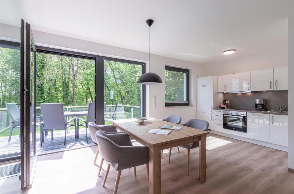 a kitchen and dining room with a table and chairs at Gelassenheit - modernes Apartment am Krakower See in Krakow am See